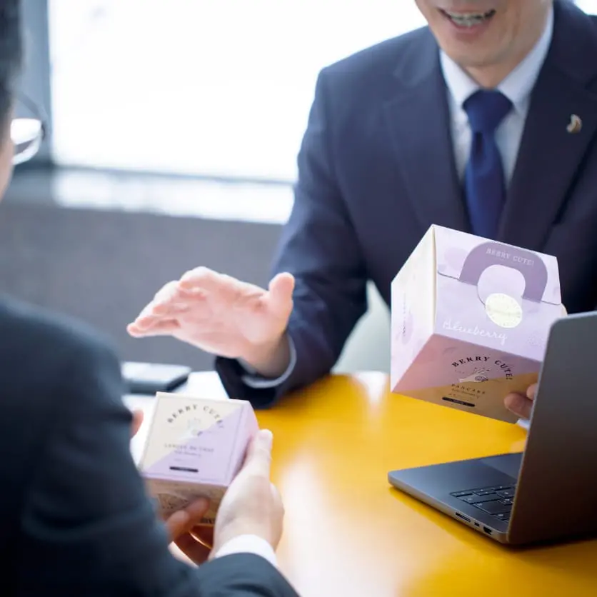 会議で和菓子を持ちながら話すビジネスシーン